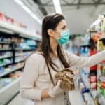 Personne faisant les courses en magasin, sélectionnant des produits alimentaires pour une livraison à domicile.