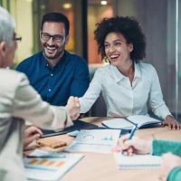 Personnes travaillant ensemble autour d’une table, échangeant des documents lors d’une assistance administrative à domicile.